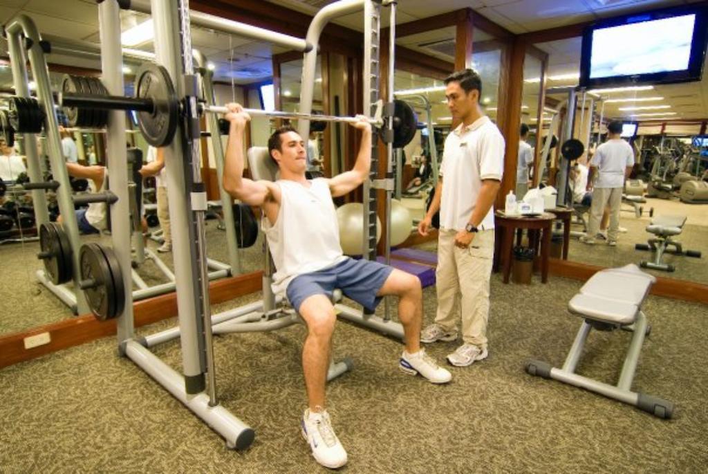 Готель Marco Polo Davao Екстер'єр фото A personal trainer assisting a client with a weight training exercise